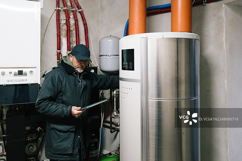 一名建筑技术人员正在检查居民楼的供暖系统图片素材