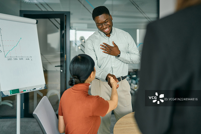 成功的会议后，来自不同背景的商界人士握手致意图片素材