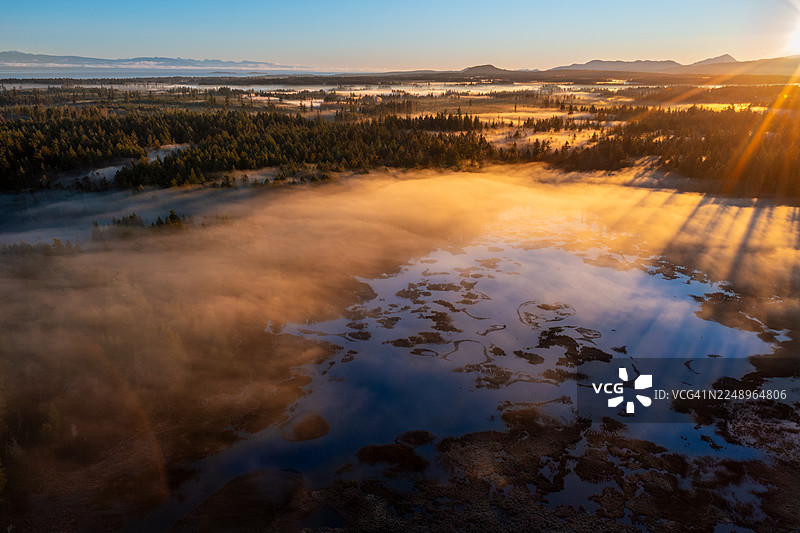 加拿大不列颠哥伦比亚省温哥华岛奎里克姆海滩哈密尔顿沼泽日出无人机镜头，光束照射图片素材