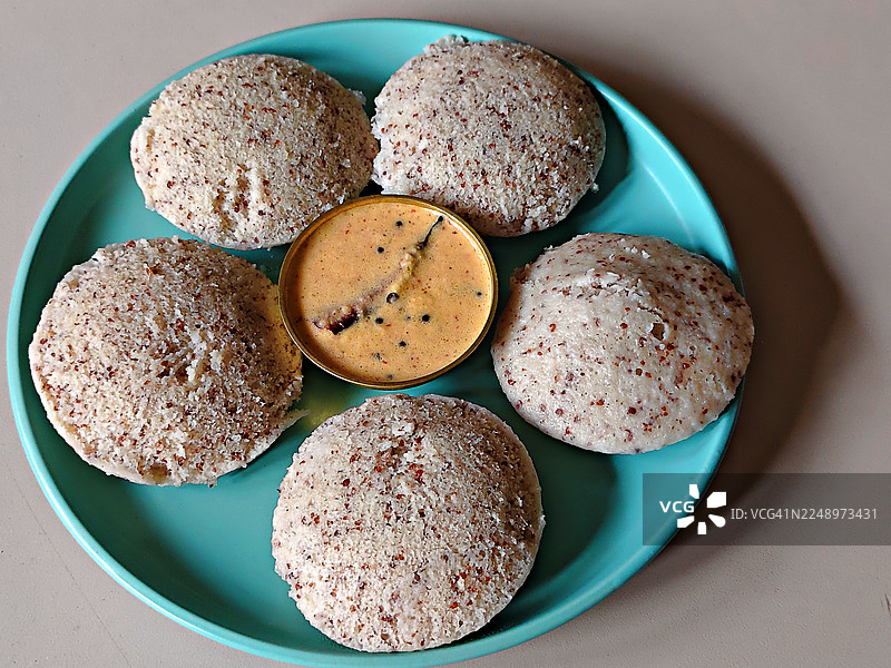 特写镜头：小米米糕搭配红辣椒椰子酱，盛放在青绿色陶瓷盘中/早餐/静物/喀拉拉邦图片素材