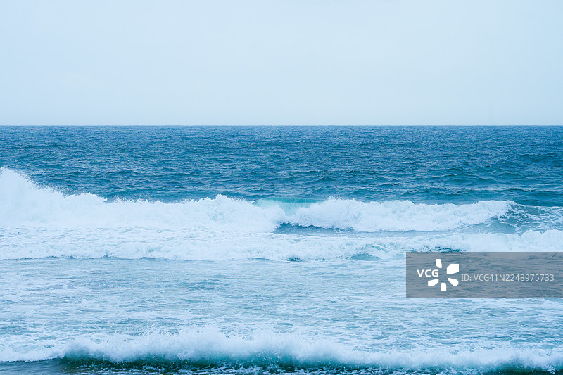 科瓦兰海滩，喀拉拉邦，印度，在柔和的蓝色时刻光线下拍下的破碎海浪图片素材