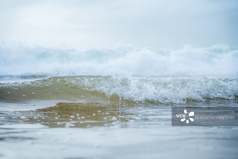 科瓦兰海滩的碎浪在柔和的晚间光线下，印度喀拉拉邦图片素材