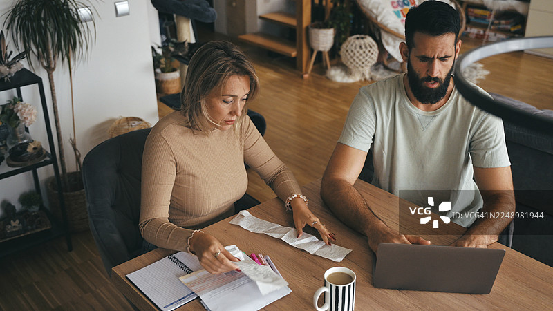 专注的西方情侣在家整理家庭账单图片素材