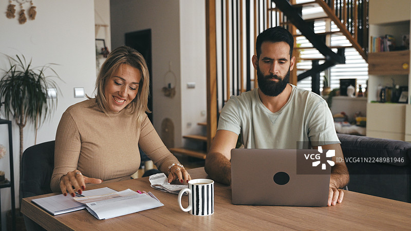 白种夫妇在餐桌上合作处理家庭财务图片素材