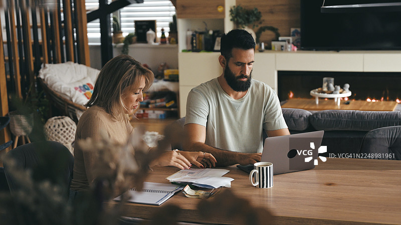白人夫妇在现代桌旁审视家庭财务图片素材