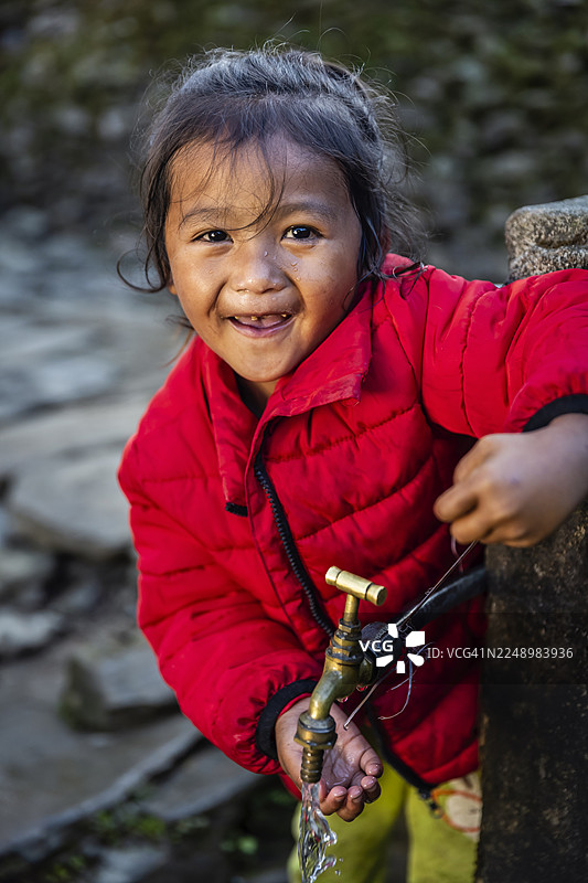 尼泊尔女孩在安纳布尔纳峰附近村庄喝水图片素材