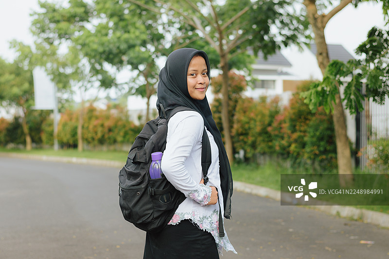 背着背包的快乐亚裔穆斯林学生肖像图片素材