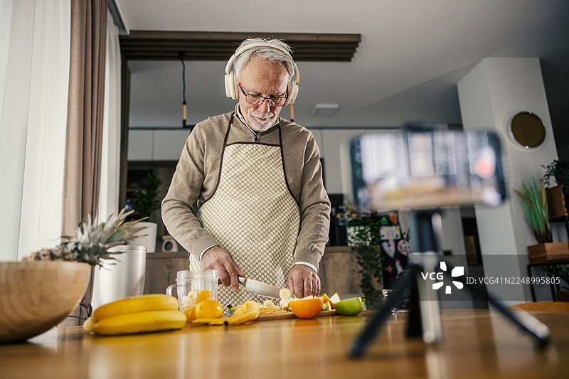 老年男性在厨房拍摄健康食品制作视频图片素材