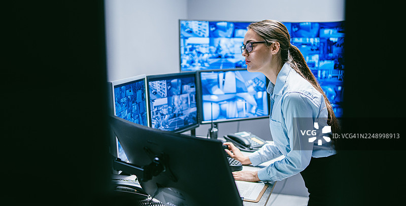 安全女操作员在控制室使用科技审查数据图片素材