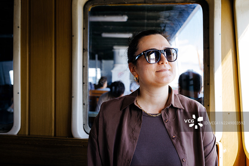 年轻的女游客在伊斯坦布尔乘坐博斯普鲁斯渡轮旅行。图片素材