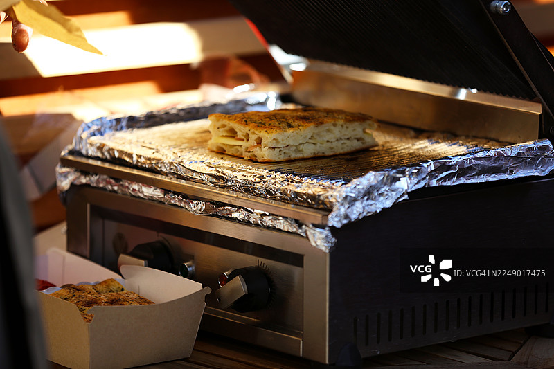 新鲜的佛卡夏火腿芝士在户外食品市场烤制图片素材