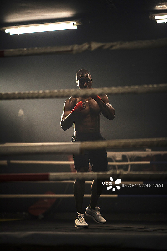 灯光下的拳击手在拳击台上准备比赛图片素材