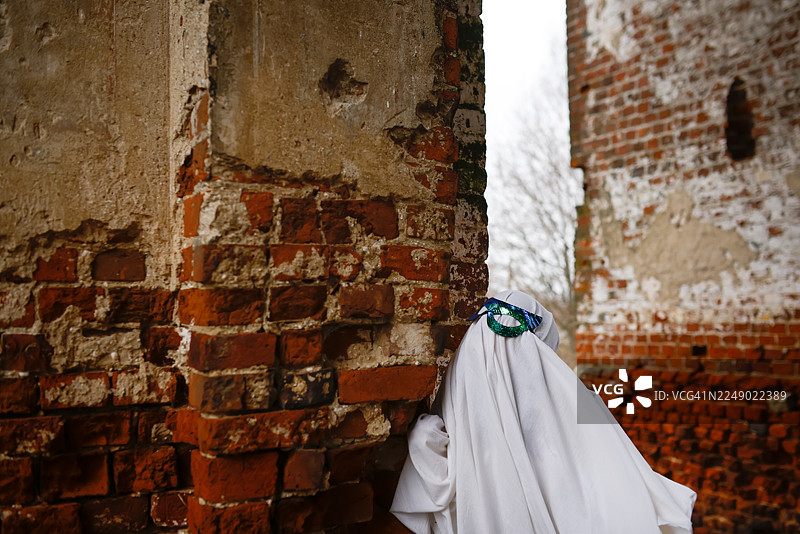 穿着戏服的孩子在被毁坏的地方探险，如同小幽灵探险家图片素材