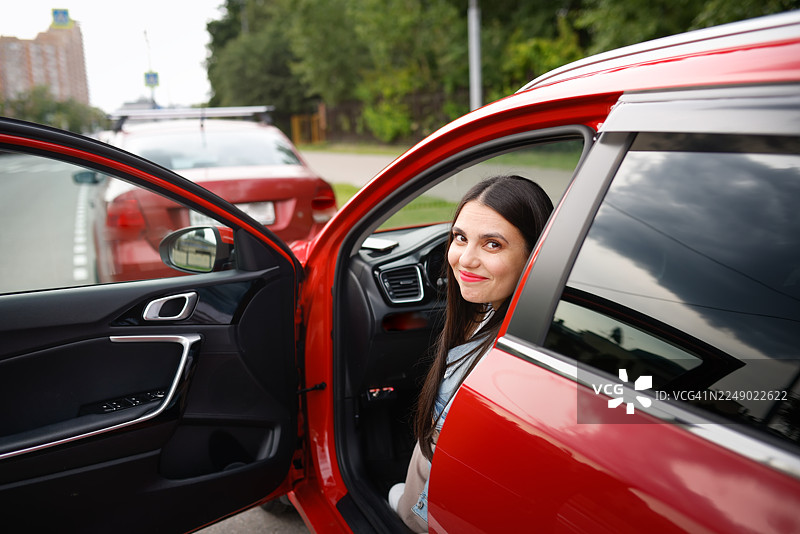 透过车窗拍摄的，一位美丽的微胖女性在驾驶座上的肖像照图片素材