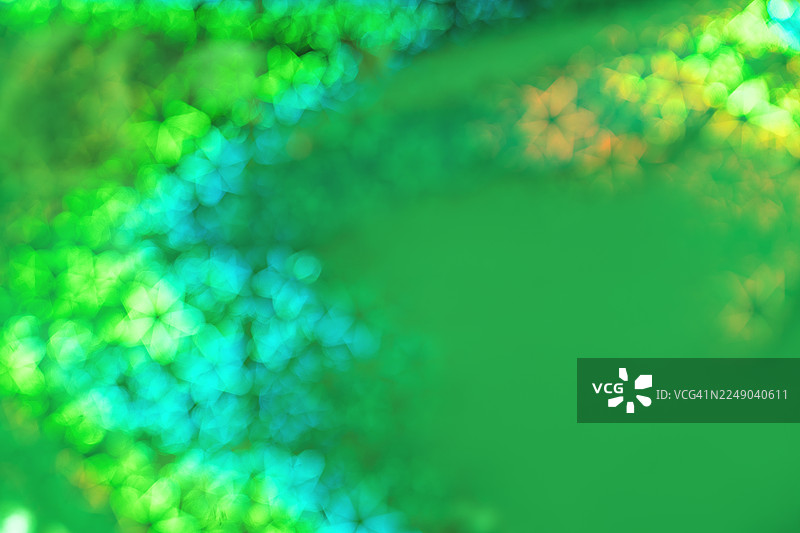 充满活力的绿色散景背景，带有闪烁的光图案，适用于抽象、节日和设计用途图片素材
