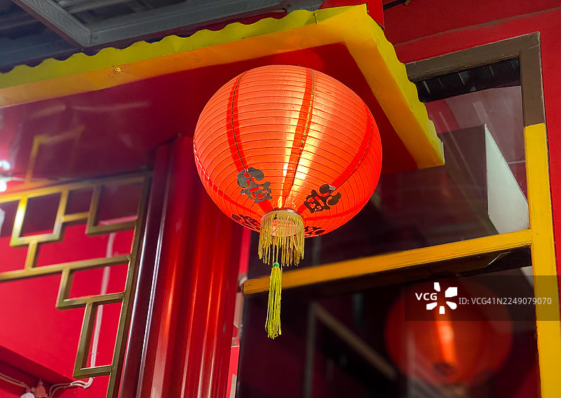 橙色中式灯笼悬挂在建筑屋顶图片素材