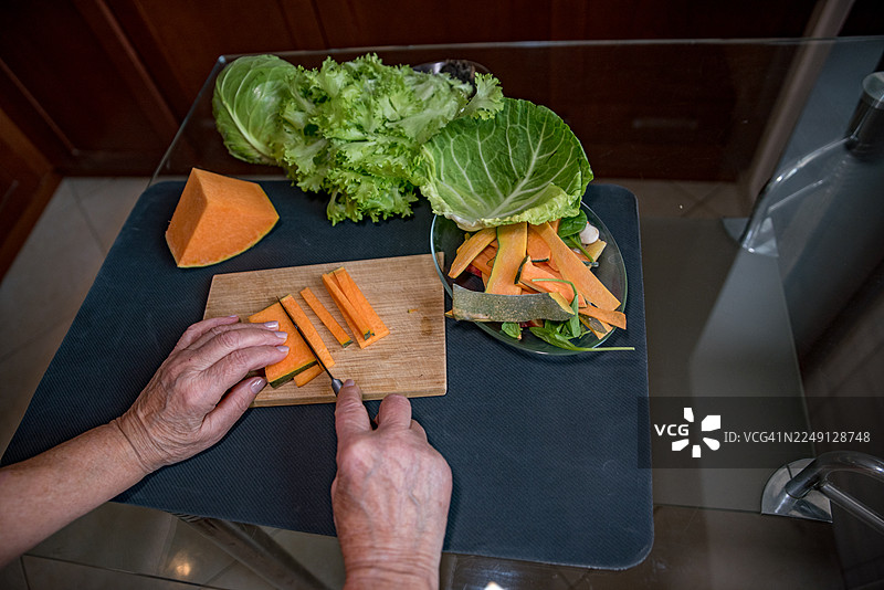 女性双手准备蔬菜。厨房桌上的蔬菜和有机废物。分类有机废物以制作堆肥的概念图片素材