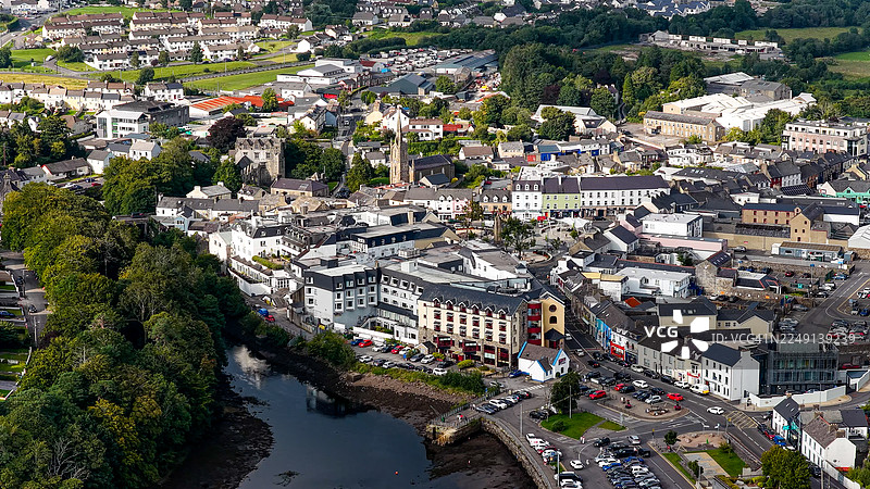 爱尔兰西北部多尼戈尔郡的鸟瞰图,展示了多尼戈尔镇中心的历史石头建筑、教堂塔楼以及贯穿城镇的埃斯克河,周围环绕着郁郁葱葱的绿色山丘,体现了城市遗产和旅游目的地的概念图片素材