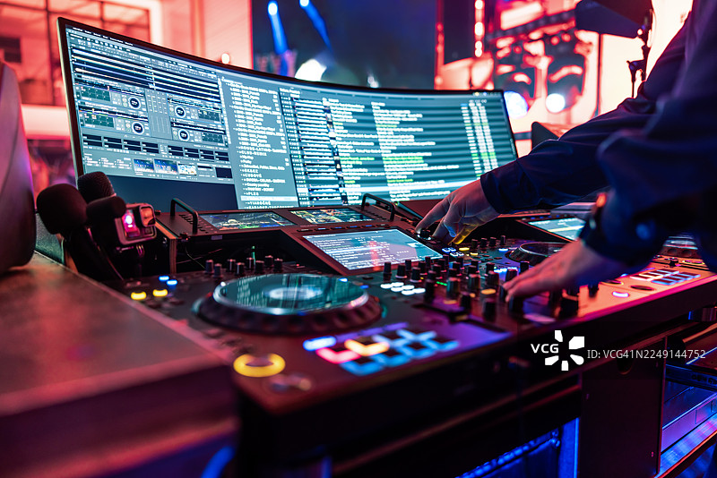 DJ双手在大型混音器上精心调节控制按钮的动感镜头图片素材
