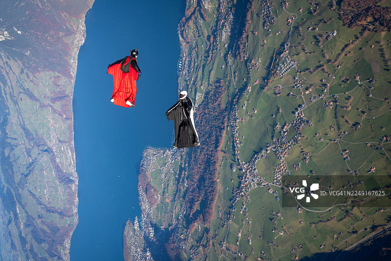 翼装飞行者翱翔于湖泊与山峦之上图片素材