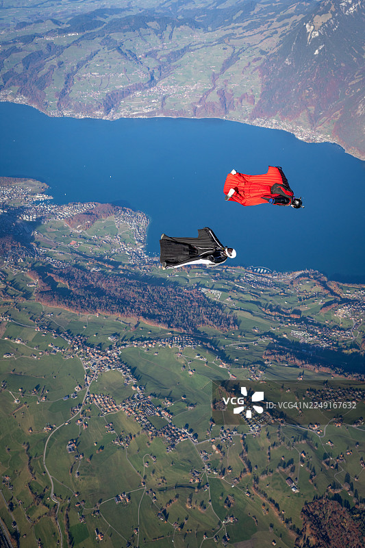 翼装飞行者翱翔于湖泊与山峦之上图片素材
