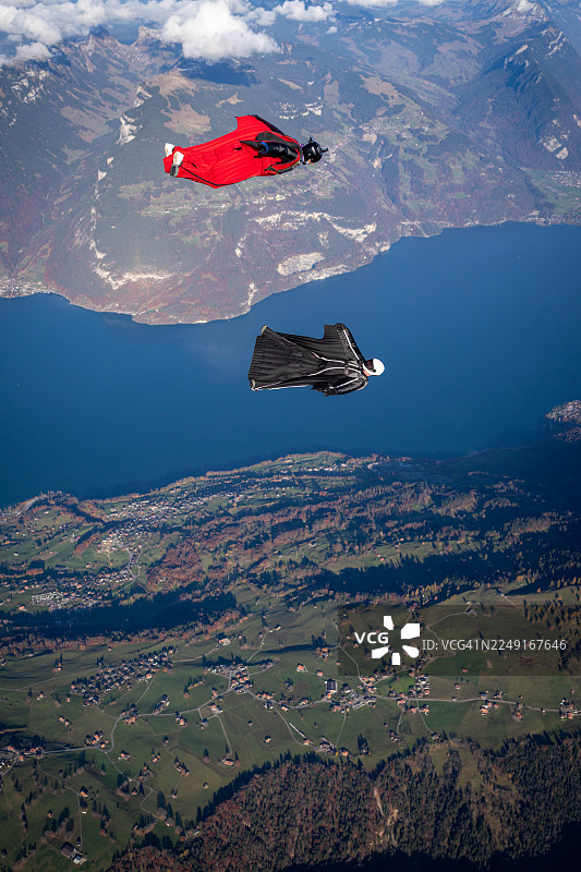 翼装飞行者翱翔于湖泊与山峦之上图片素材