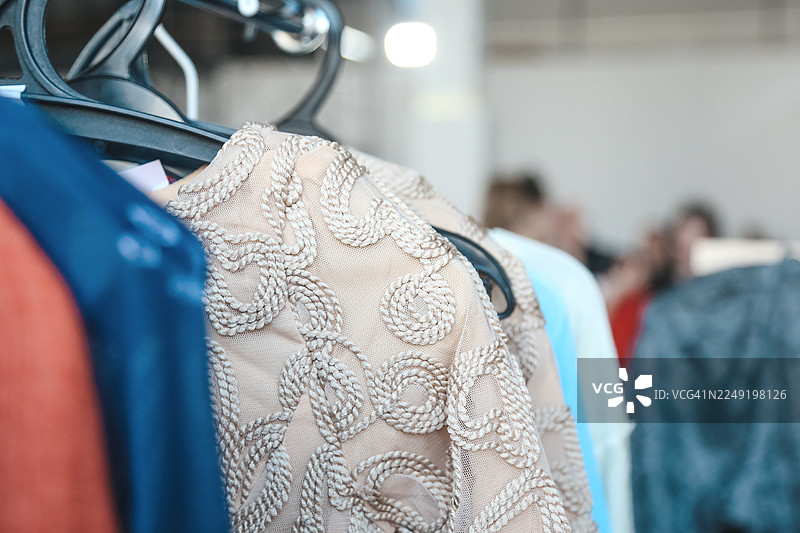 米色刺绣连衣裙，背景是模糊的服装店图片素材