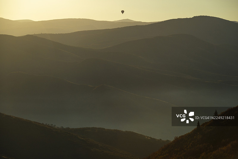热气球在烟雾缭绕的山峦上空图片素材