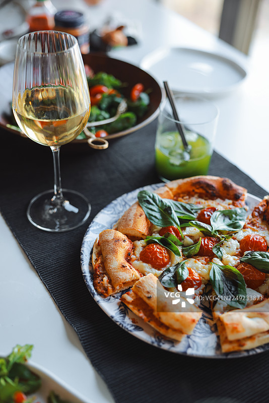 自制正宗意大利披萨、新鲜沙拉和白葡萄酒图片素材