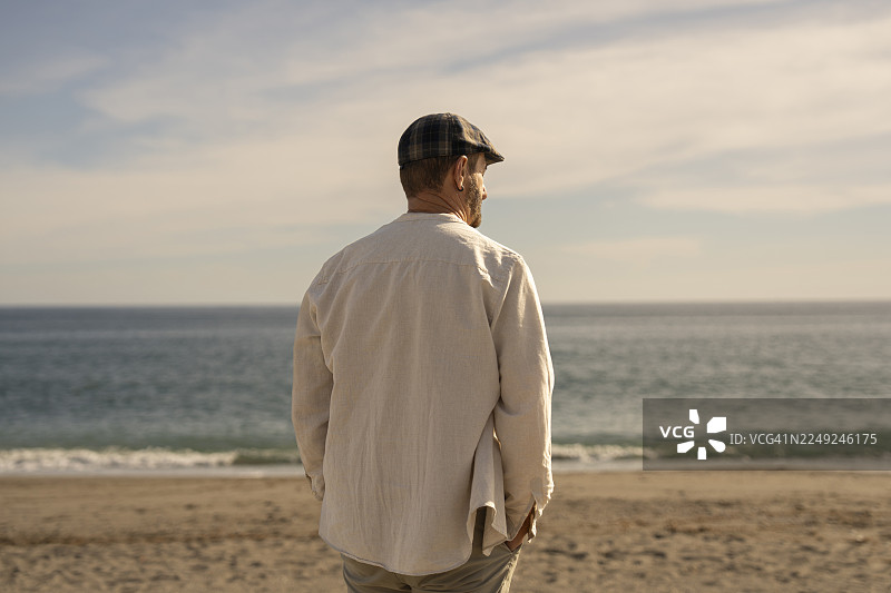 日落时分，男子独自在海滩上行走图片素材