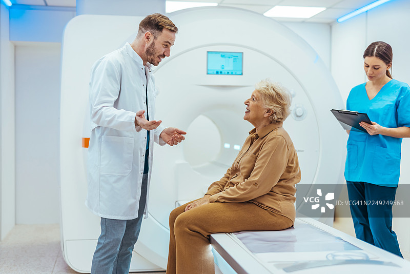 医生在核磁共振室咨询老年患者，护士在一旁记录图片素材