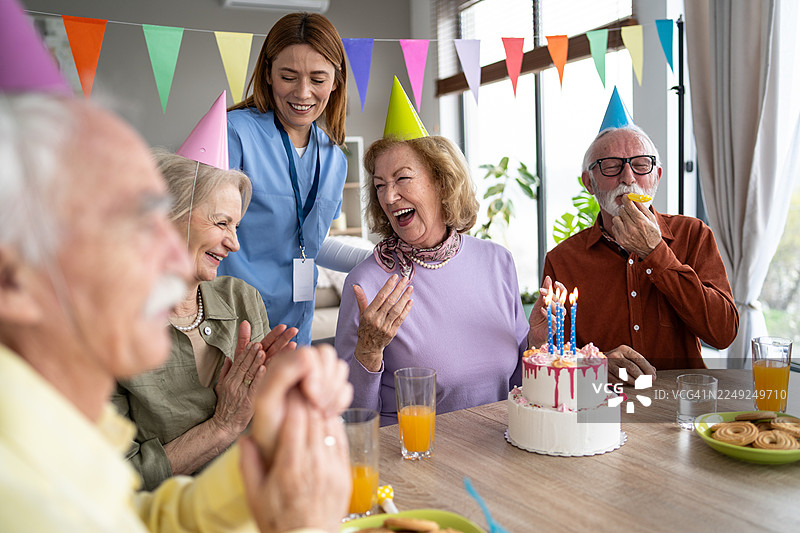 老人们开怀大笑，分享生日蛋糕，共庆生日图片素材