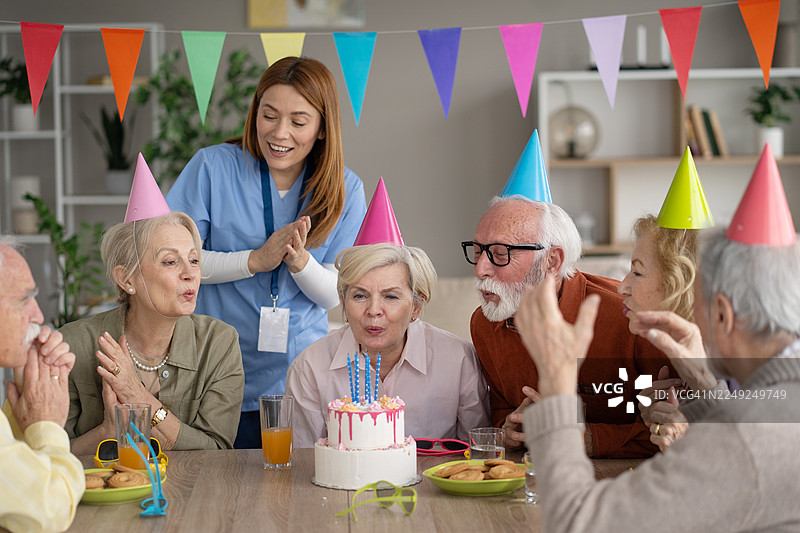 老年人欢笑着用节日的生日蛋糕庆生图片素材