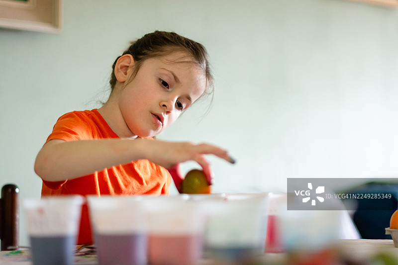 小女孩为节日传统染制复活节彩蛋图片素材