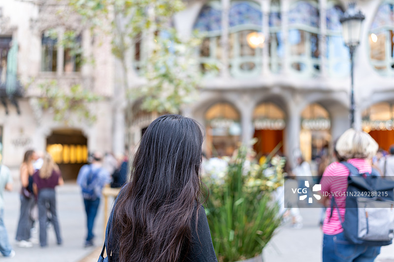 一名女子在西班牙巴塞罗那旅行时欣赏巴特罗之家建筑图片素材
