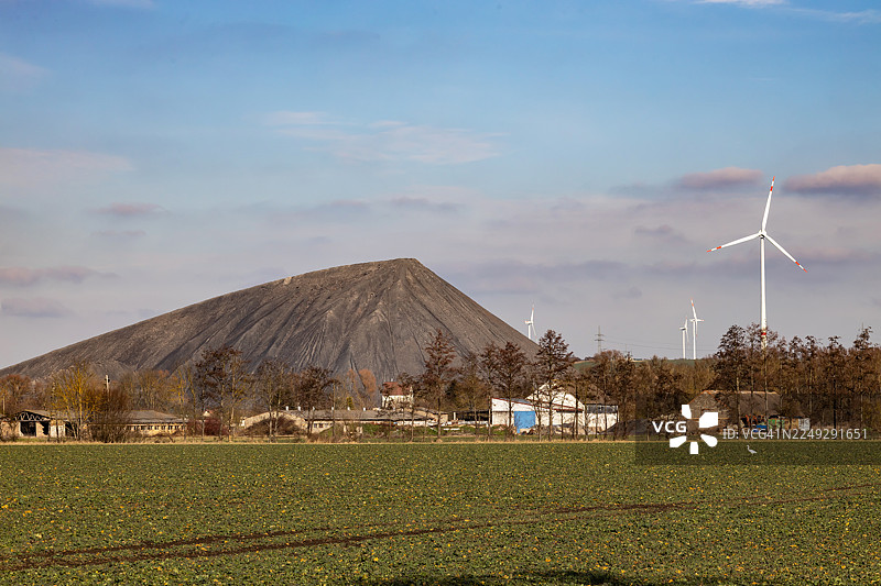 旧矿山的废料堆，背景是现代风力涡轮机图片素材