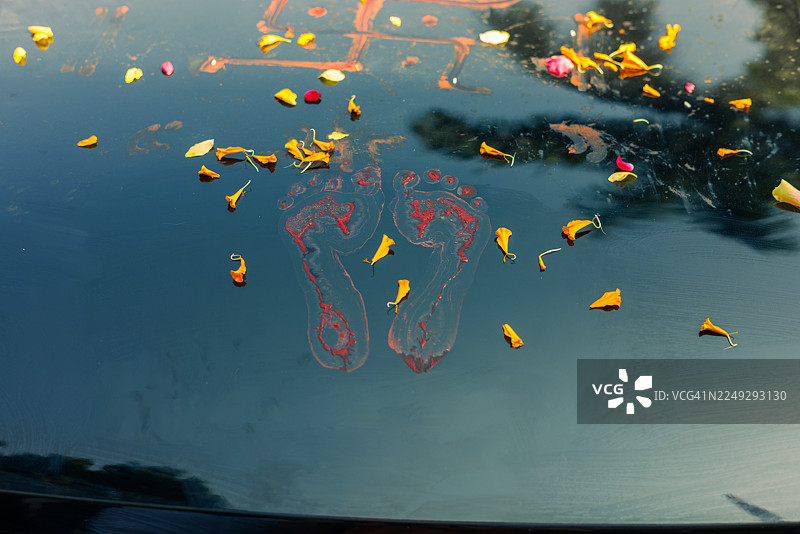 新车祈福仪式，印有孩童红色的脚印和花瓣图片素材