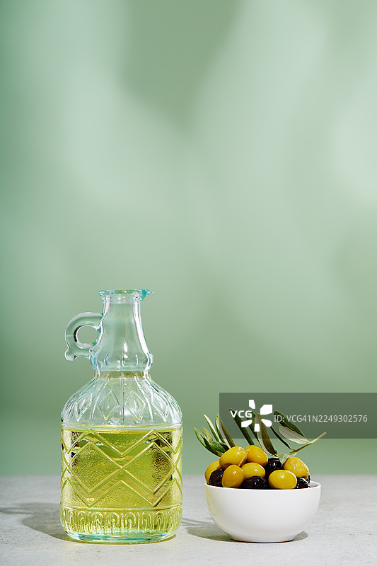 一瓶橄榄油和一碗绿橄榄及黑橄榄图片素材