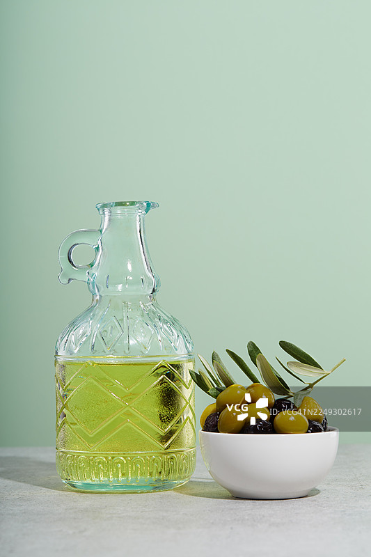 一瓶橄榄油和一碗绿色及黑色的橄榄图片素材
