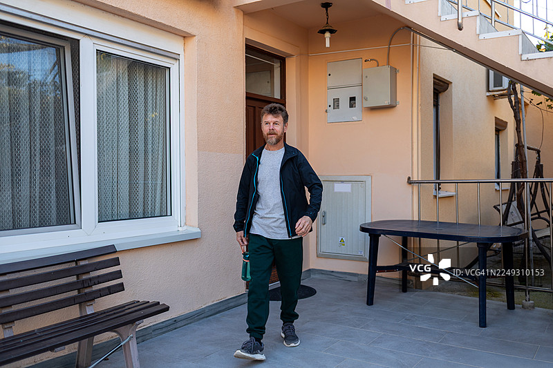 中年男子在户外持运动水壶行走图片素材