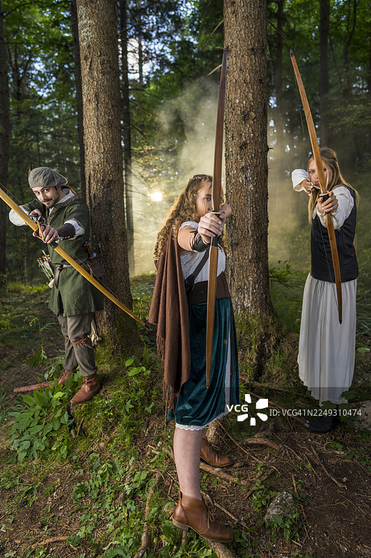 年轻的中世纪弓箭手在森林中熟练地练习射箭图片素材