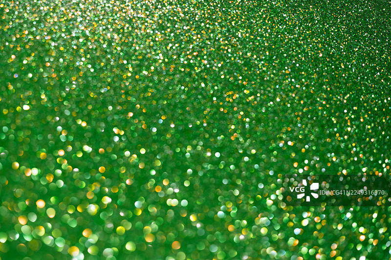 金色散景灯光下的绿色闪亮闪光背景图片素材