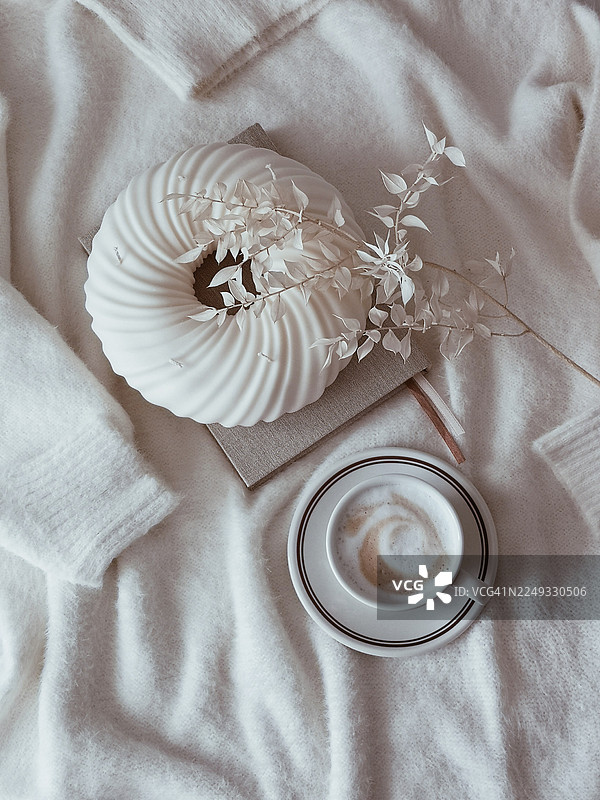 咖啡馆里优雅的餐桌布置。杯中的热巧克力或咖啡，桌上摆放着白色蜡烛和装饰品。图片素材