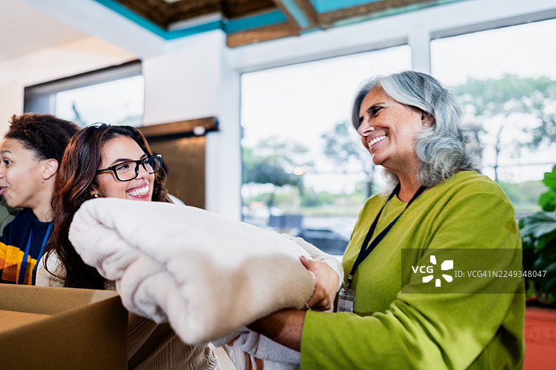 社区志愿者在捐赠活动中整理衣物图片素材