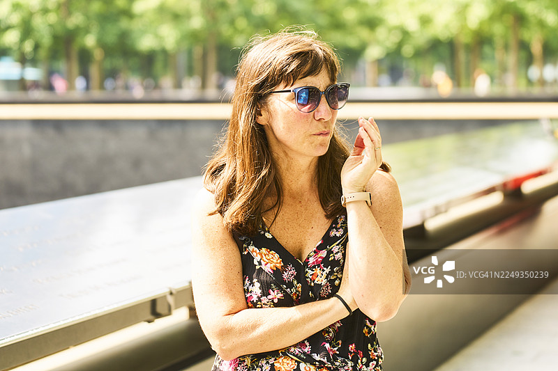 一位女士在纽约市9/11纪念馆前沉思图片素材