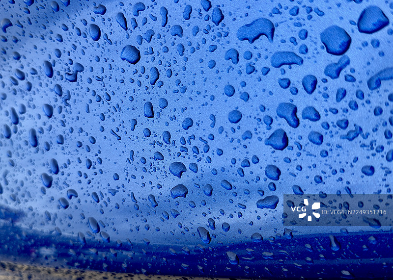 特写镜头下油漆上的雨滴。图片素材