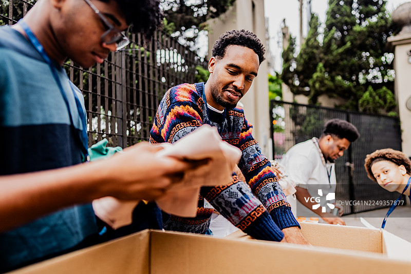年轻的志愿者在社区服务中整理捐赠物品图片素材