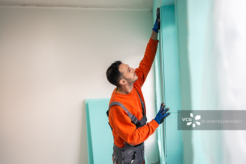 熟练工人将 XPS 保温材料应用于房屋墙壁图片素材