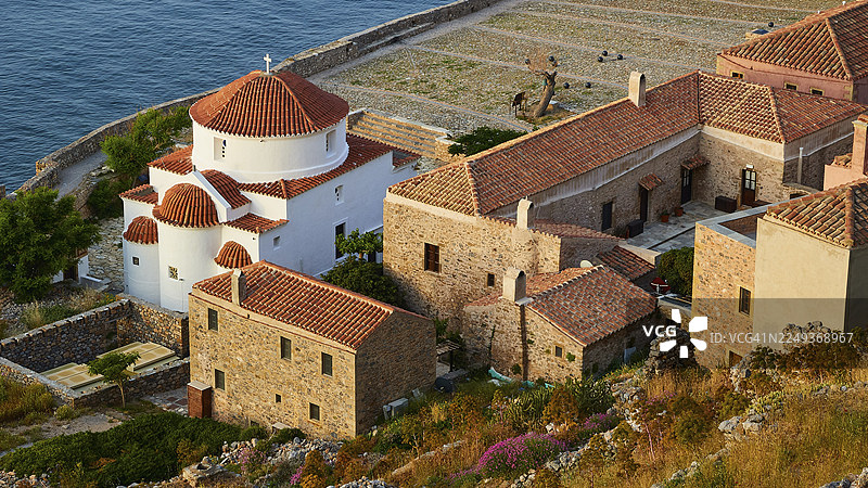 柔和的晨光,圣母玛利亚·克里萨菲蒂萨圣母教堂,美丽的海滨小镇,教堂和传统建筑依海而建,莫奈姆瓦夏,莫奈姆瓦西亚,马尔瓦西,拜占庭小镇,岩石岛,堡垒,拉科尼亚,伯罗奔尼撒半岛图片素材