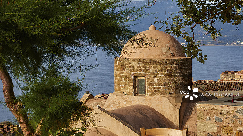 柔和的晨光，俯瞰圆顶和大海，绿树和瓦屋顶构成的画面，莫奈姆瓦夏（Monemvasia），马尔瓦西（Malvasy），拜占庭小镇，岩石岛，堡垒，拉科尼亚（Laconia），伯罗奔尼撒（Peloponnese），希腊半岛图片素材